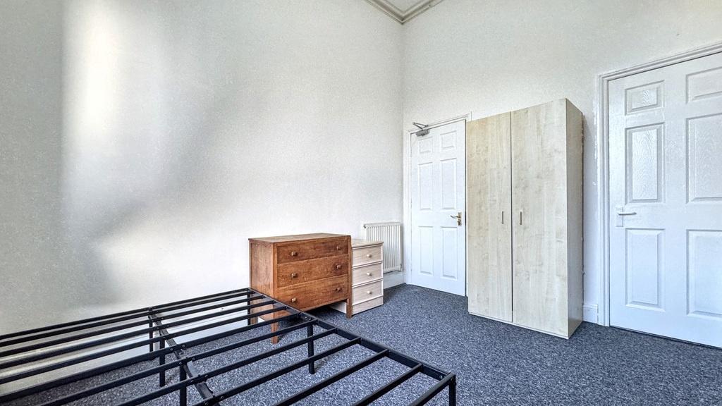 Bright, simply furnished bedroom with neutral d...