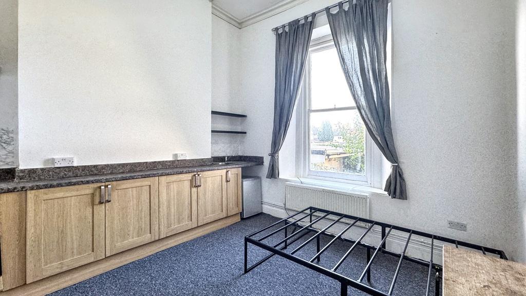 Bright bedroom with a large window and fitted s...