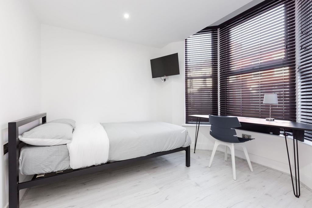 A spacious, modern bedroom featuring a simple b...