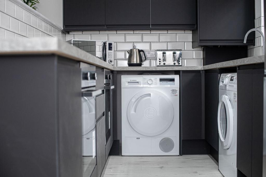 Modern kitchen featuring sleek black cabinets, ...