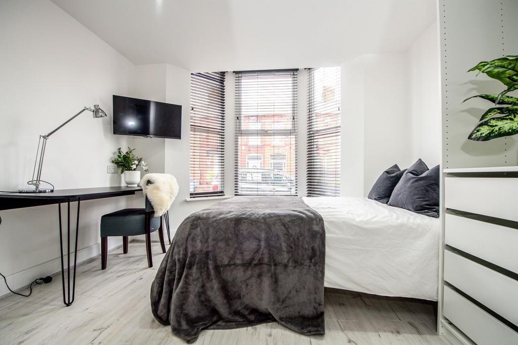 Bright and modern master bedroom featuring a sp...