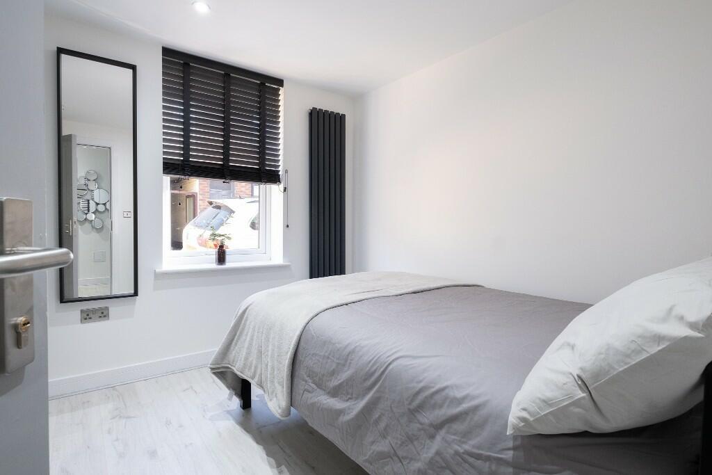 A neat and modern single bedroom with a comfort...