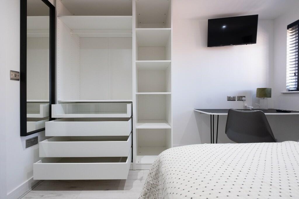 Bright and tidy bedroom featuring a white built...
