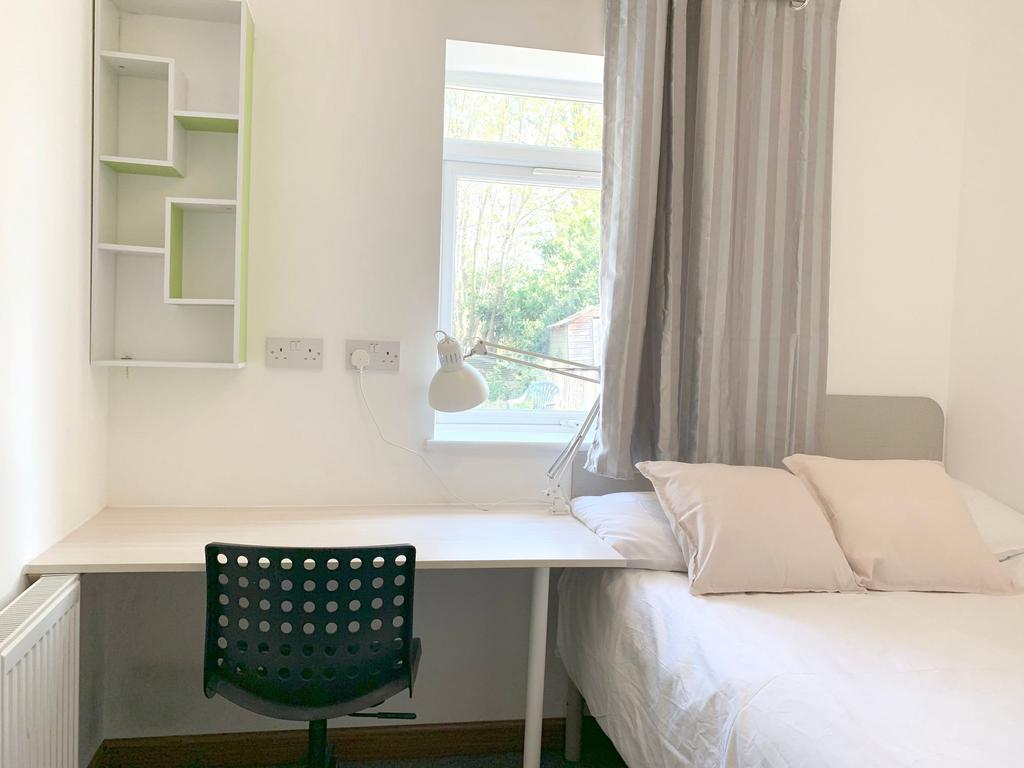 A bright and tidy single bedroom featuring a co...