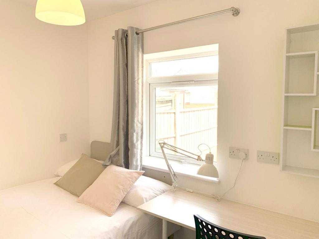 A bright and tidy single bedroom featuring a ne...