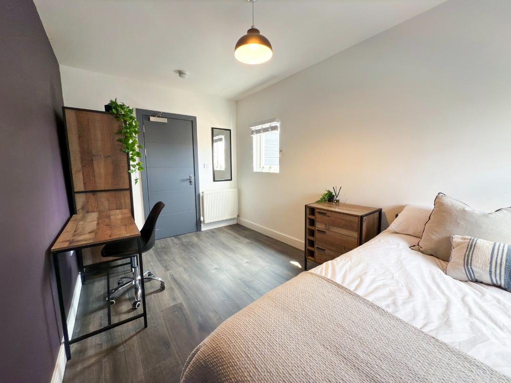A bright and neat bedroom featuring a comfortab...