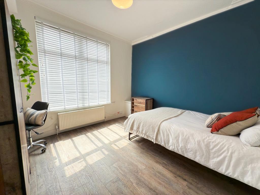 A bright and inviting bedroom featuring a large...