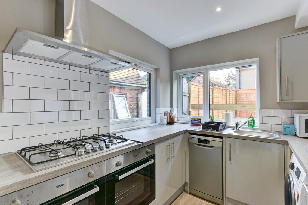 Bright and functional kitchen with white tiled ...
