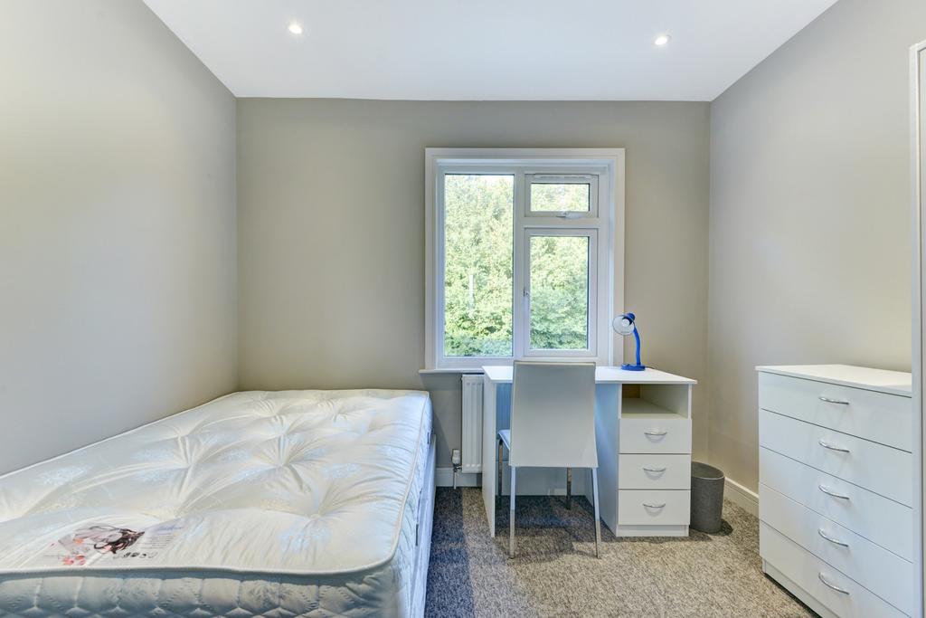 A bright and tidy bedroom featuring a comfortab...