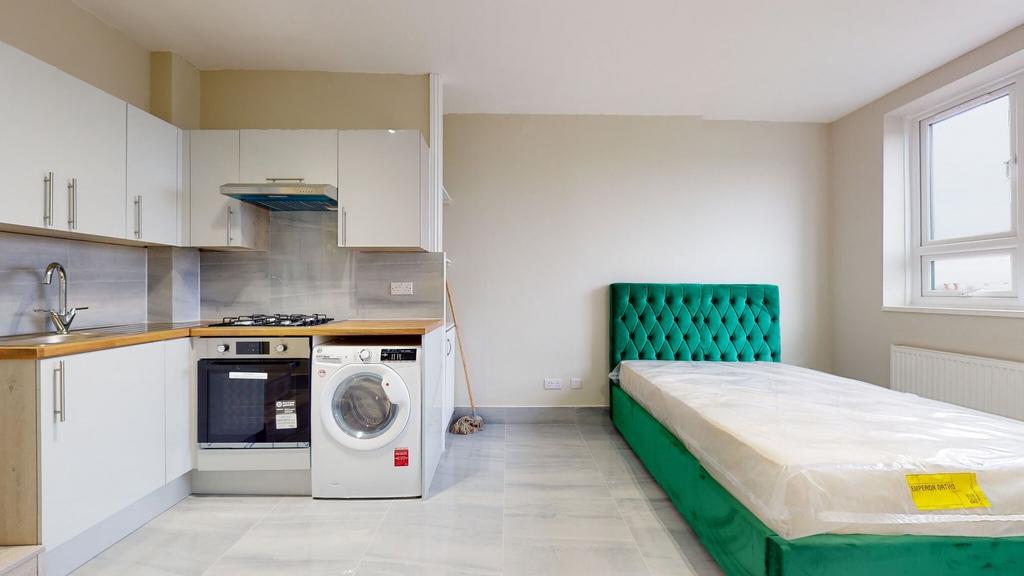 Modern kitchen area with white cabinetry, woode...
