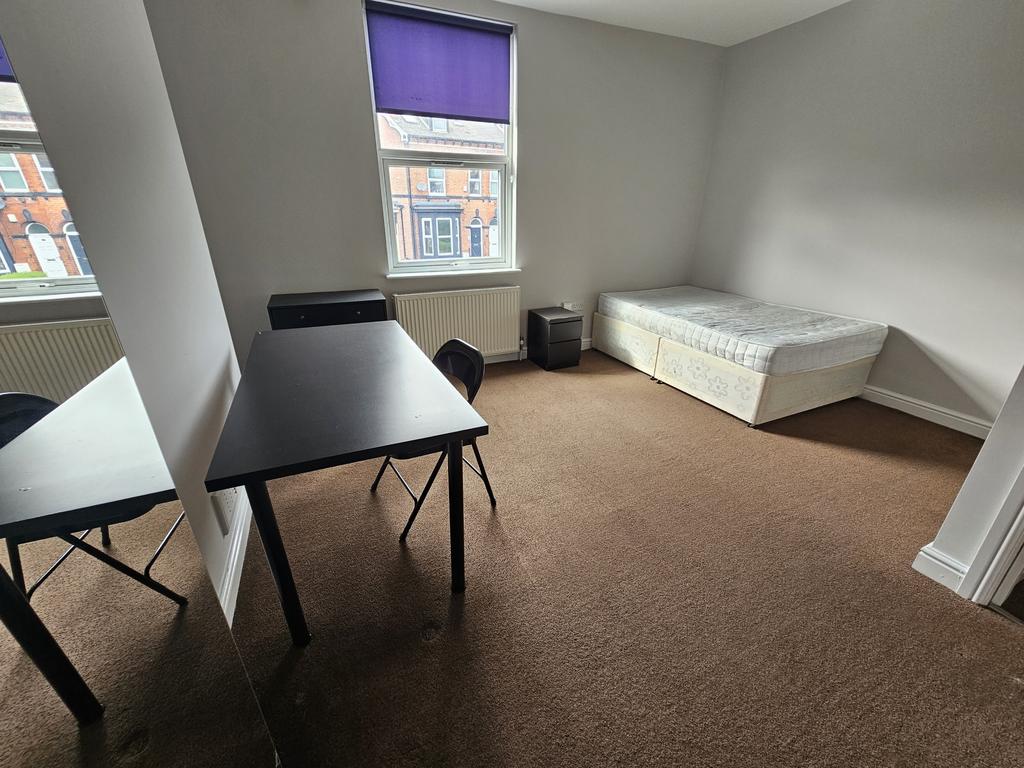 A bright and tidy bedroom featuring a single be...