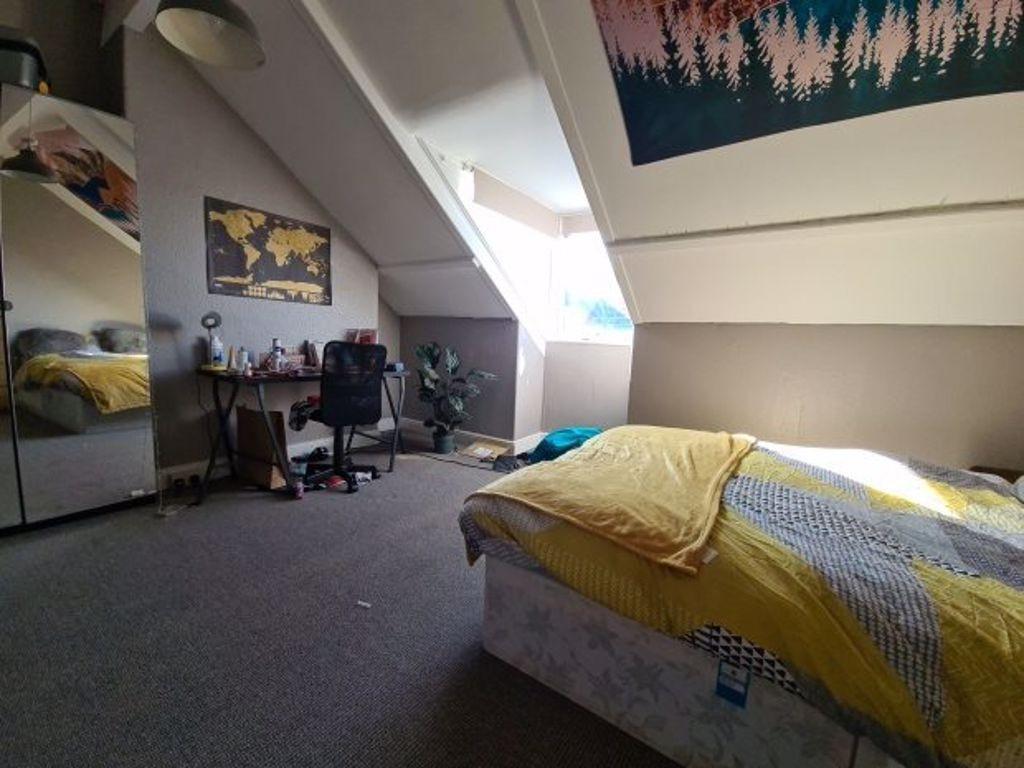 A well-lit bedroom featuring a comfortable doub...