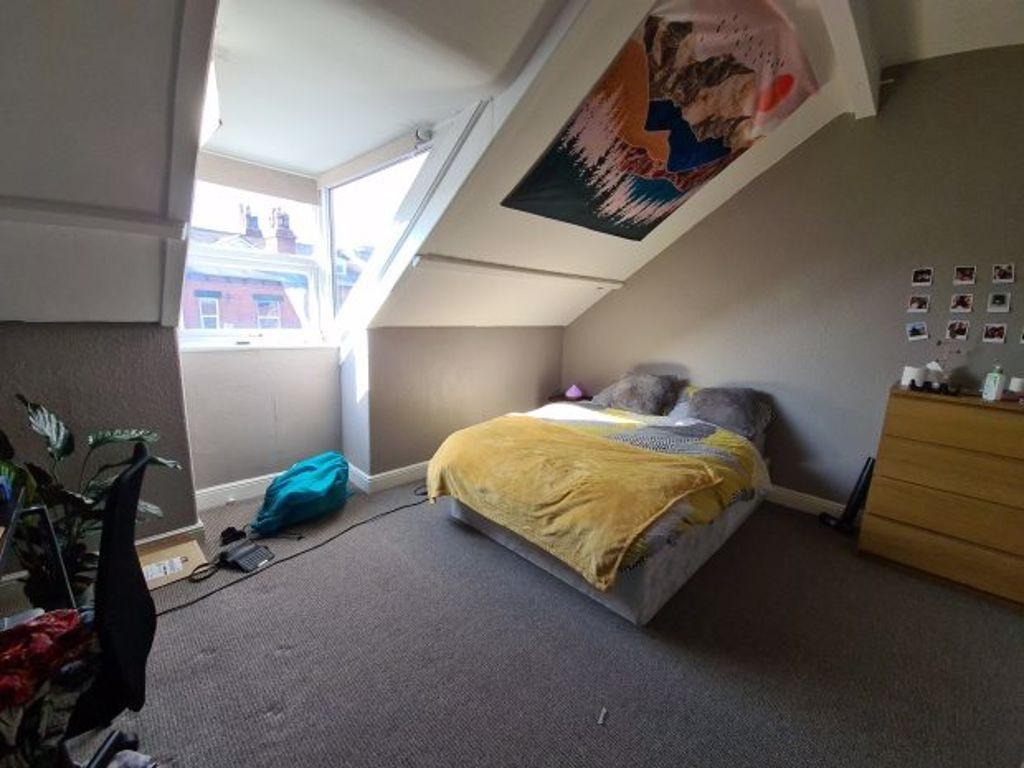 A cozy and well-lit bedroom featuring a double ...