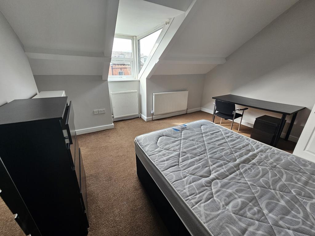 A neatly maintained bedroom with ample natural ...