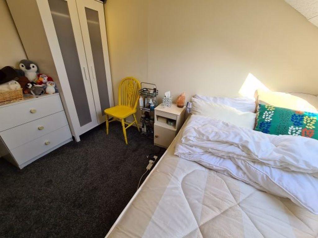 A bright and tidy small bedroom featuring a com...