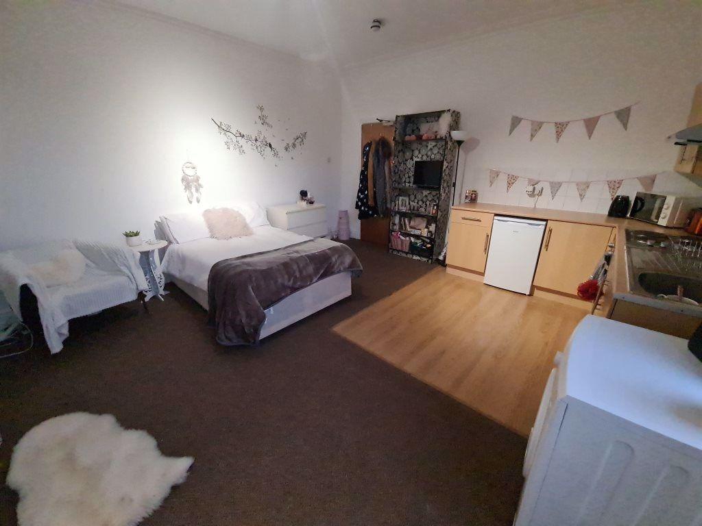 A spacious and cozy bedroom featuring a comfort...