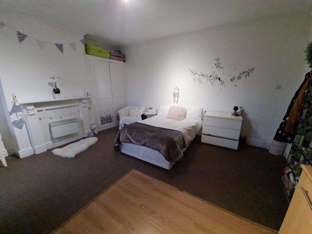 A spacious and warmly decorated master bedroom ...