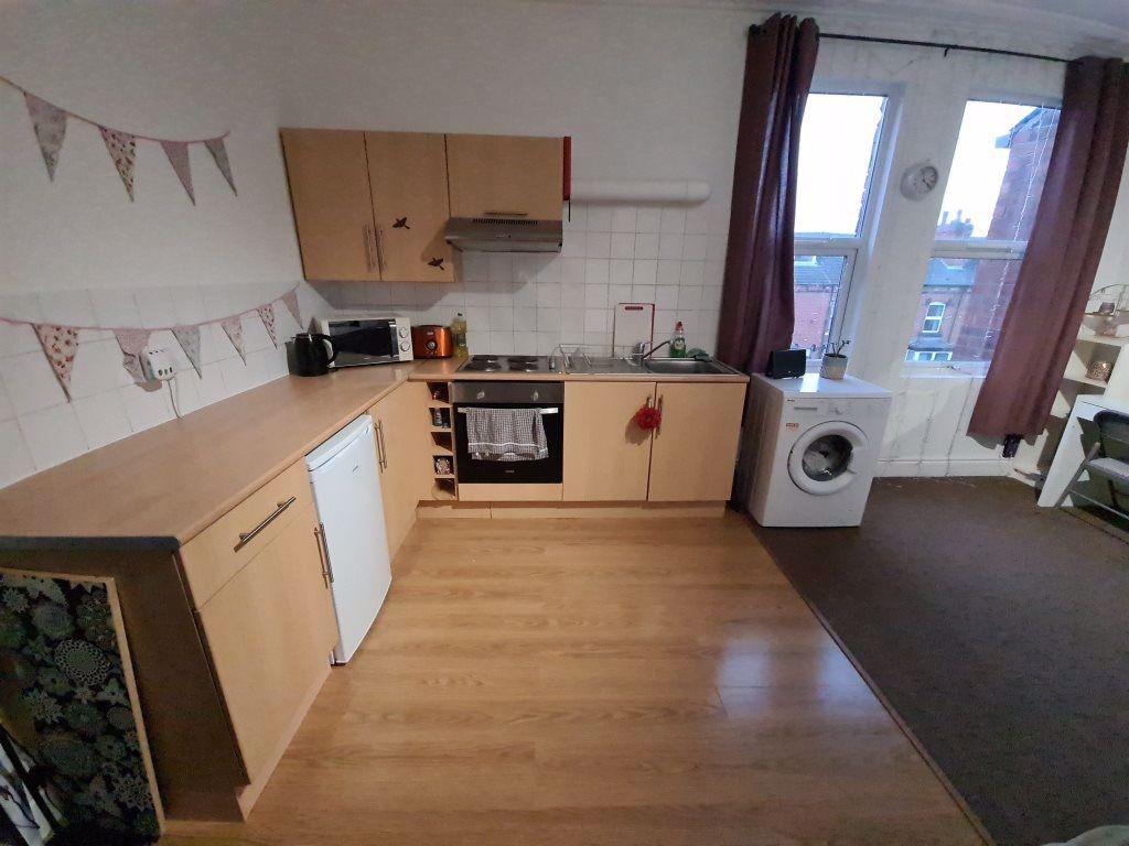 A bright and tidy kitchen featuring wooden cabi...