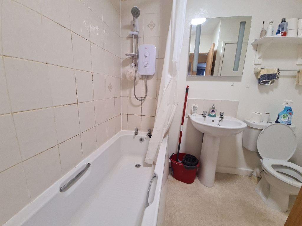 A functional bathroom featuring a bathtub with ...