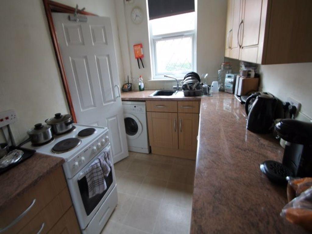 Bright galley-style kitchen with wooden cabinet...