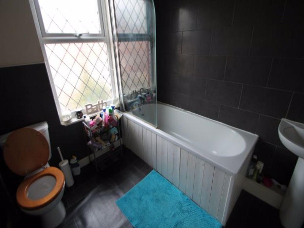 Bright bathroom with a full-size bathtub, tiled...