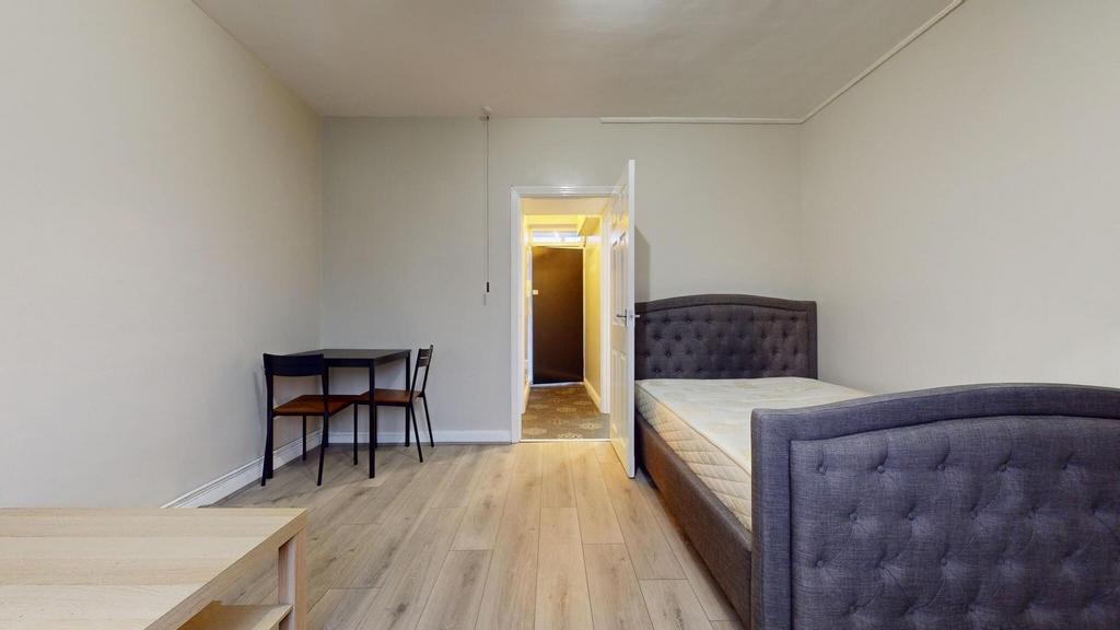 A neat and inviting single bedroom with a cushi...