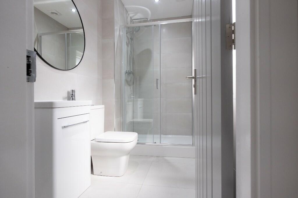 Bright, modern bathroom with a walk-in glass sh...