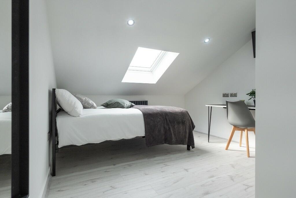Bright, minimal attic double bedroom with a sky...