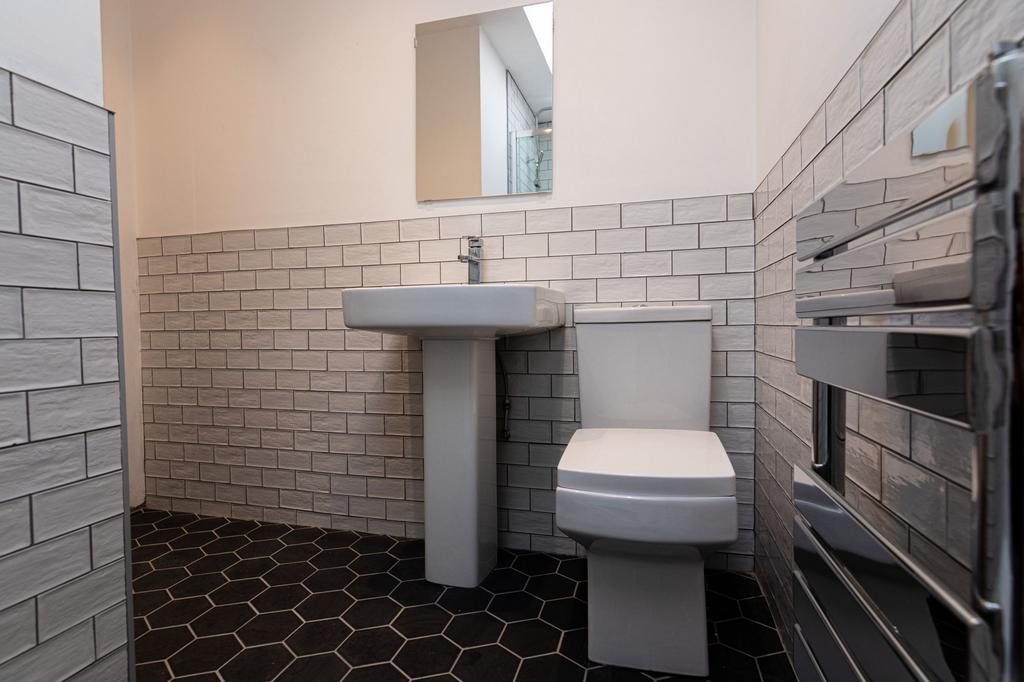 Modern tiled bathroom with a pedestal sink, con...