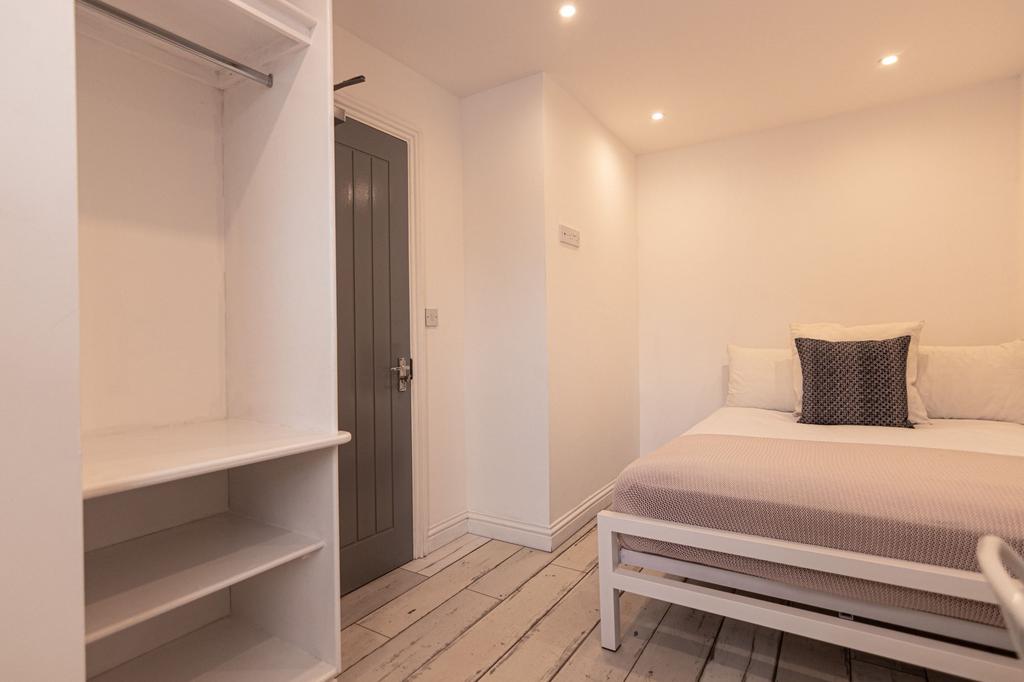 Bright, neatly presented bedroom with crisp whi...