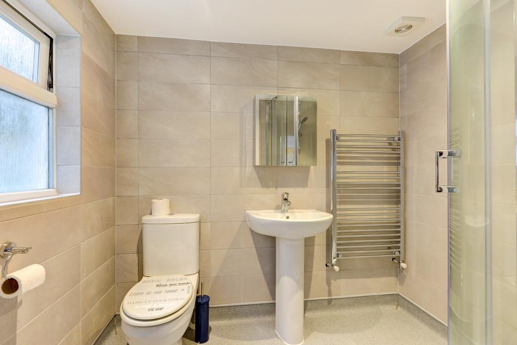 A modern, clean bathroom featuring a toilet, a ...