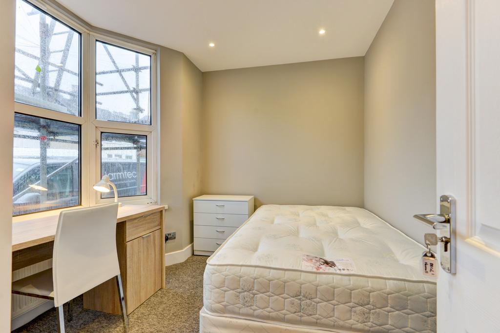 A cozy and tidy single bedroom with a comfortab...