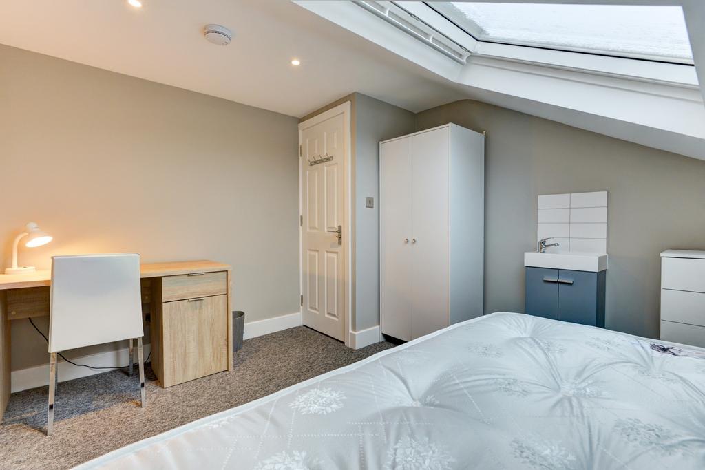 Bright and tidy bedroom with a comfortable bed,...