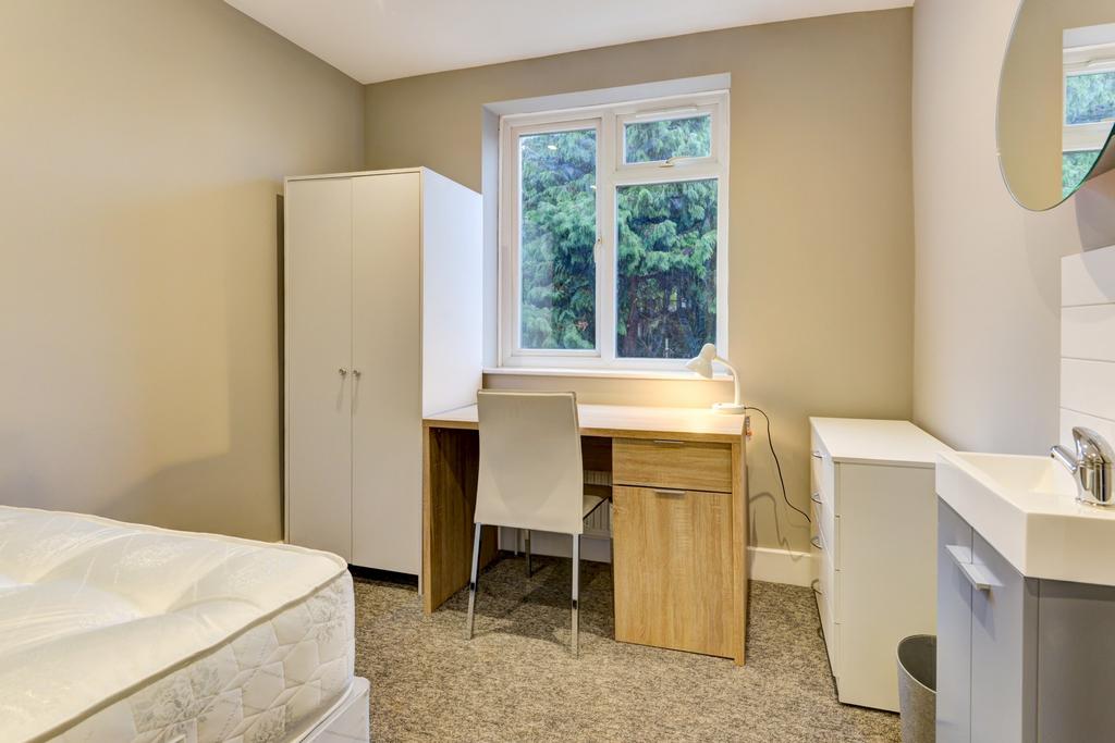 A simple, tidy bedroom featuring a window that ...