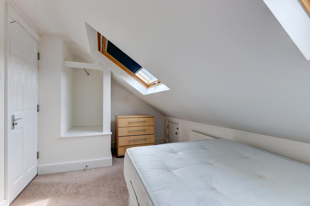 Bright attic bedroom with a skylight, neutral d...