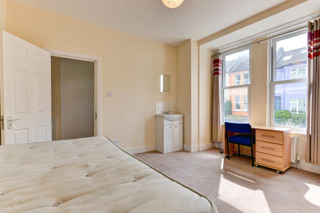 A bright and airy master bedroom featuring larg...