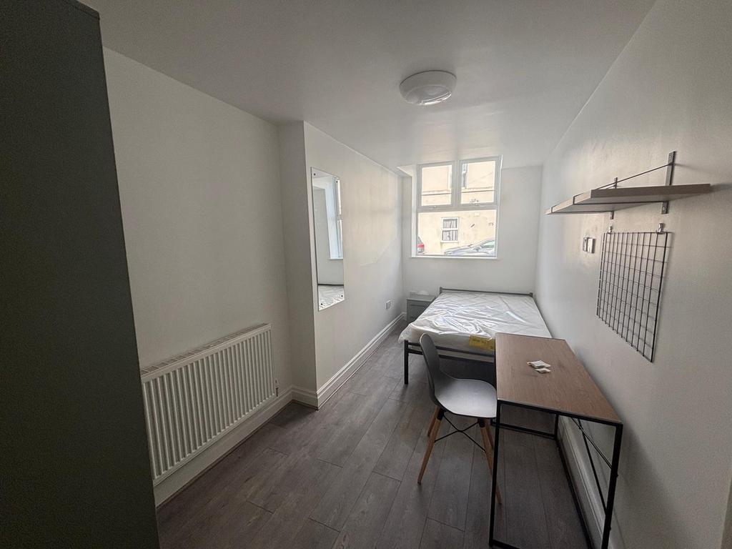 This cozy double bedroom features ample natural...