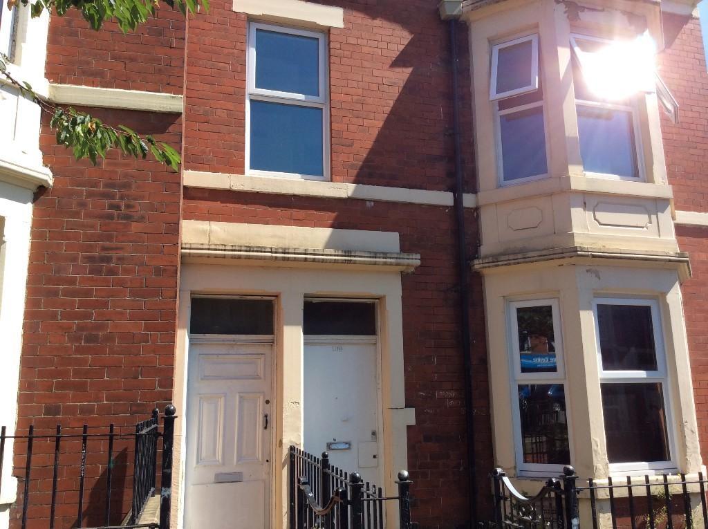 Red-brick terraced house frontage with bay wind...