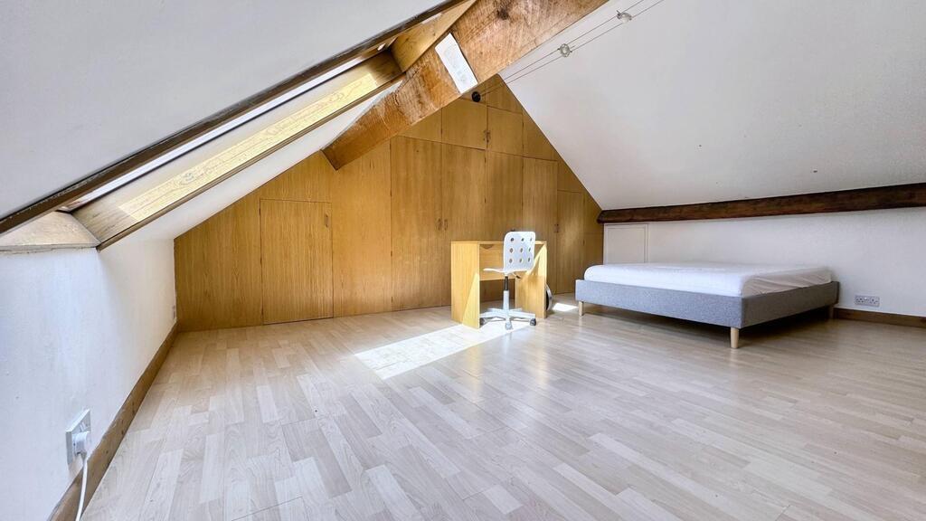 Bright, renovated attic bedroom with sloped cei...