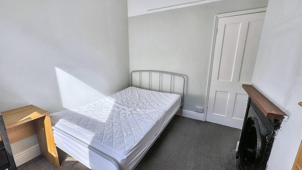 Bright, simply furnished bedroom with large win...