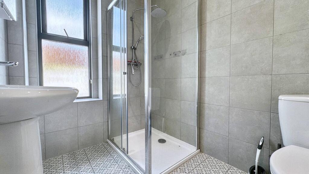 Bright, modern bathroom with walk-in shower, cl...