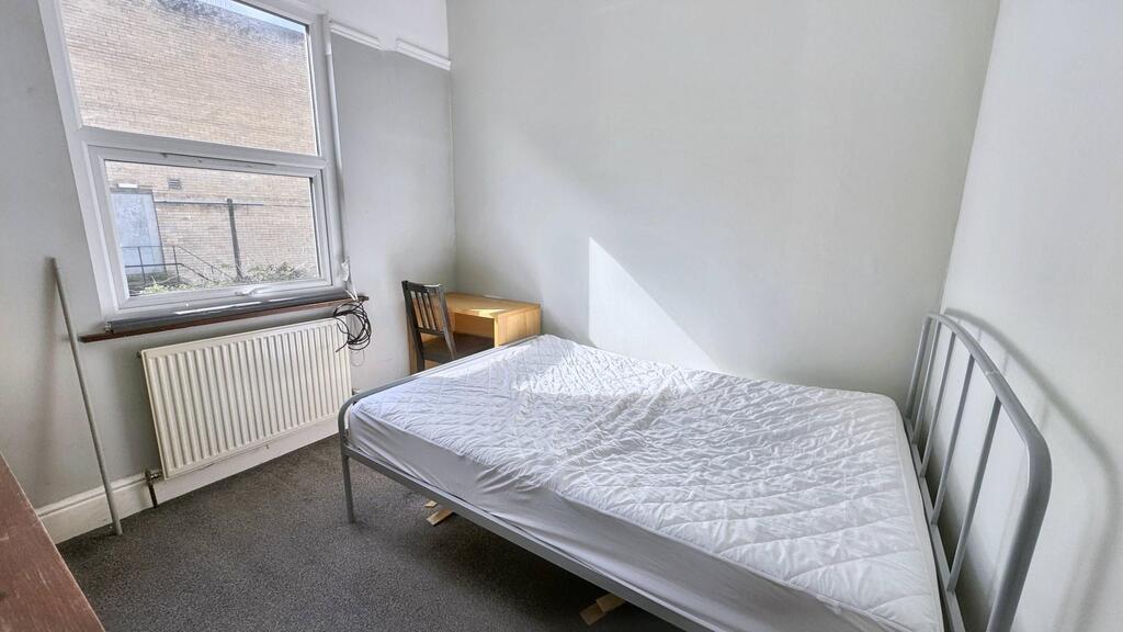 Bright, simply furnished single bedroom with a ...