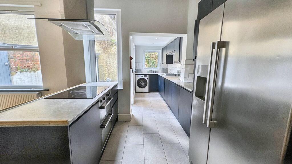 Bright modern galley kitchen with stainless-ste...