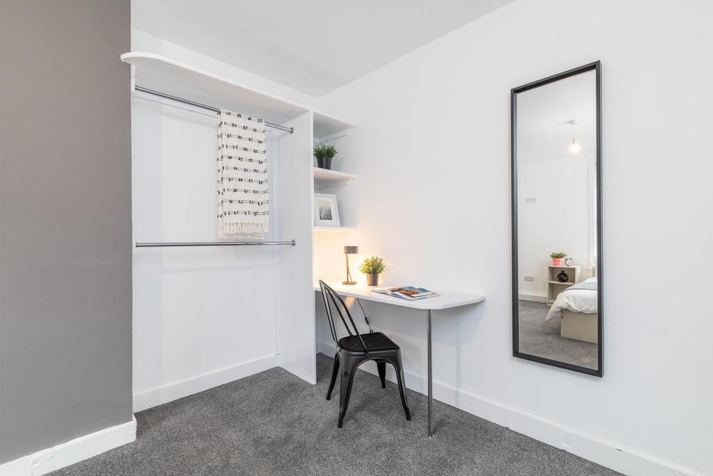 Bright, modern bedroom with neutral decor featu...