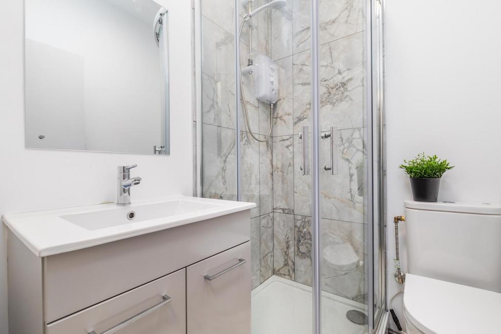 Bright, modern bathroom with a glass-enclosed s...