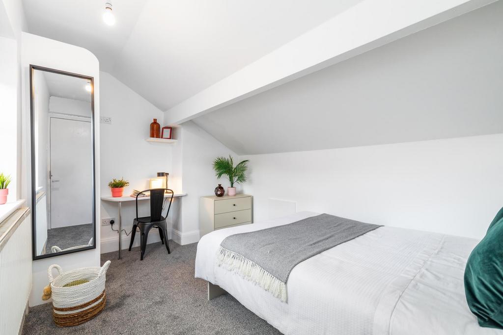 Bright, neatly styled attic bedroom with a comf...