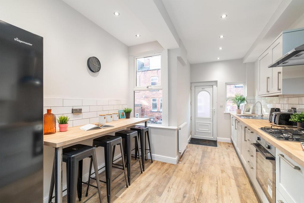 Bright modern galley kitchen with a breakfast b...