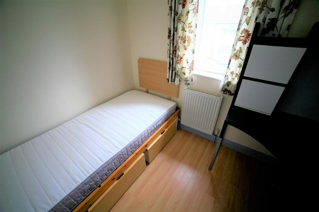 This cozy single bedroom features a comfortable...
