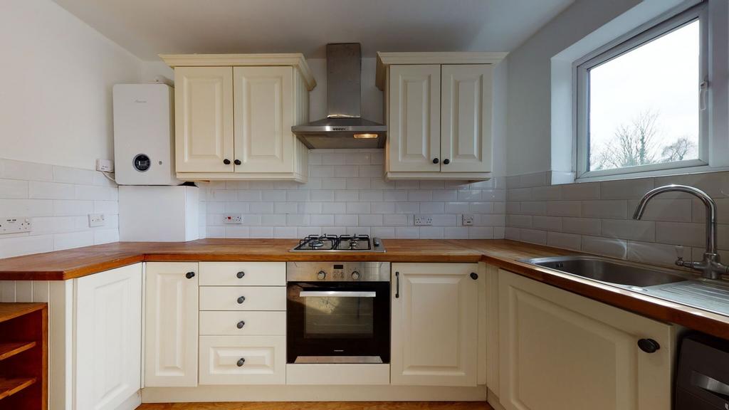 Bright and clean kitchen featuring cream cabine...