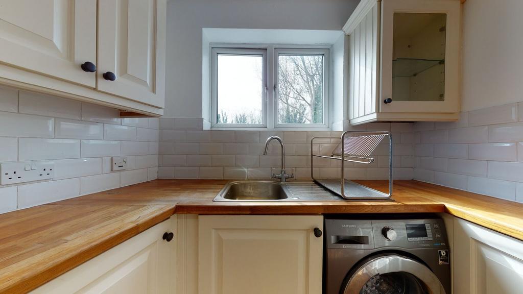Bright and tidy kitchen featuring cream cabinet...